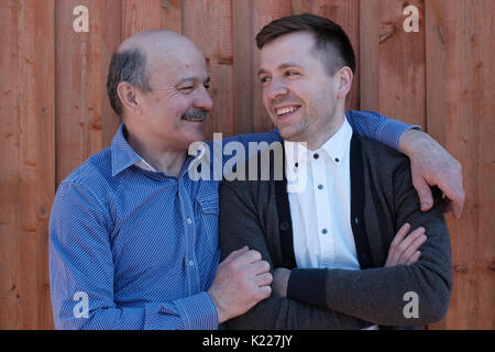 Vater und Sohn einander auf Holz- Hintergrund. Stockfoto