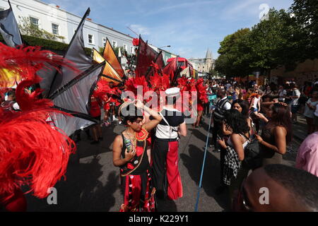 Ausführende von Sunshine International Arts zu einer Schweigeminute in Gedenken an die Opfer der Grenfell Turm Brand während der zweite und letzte Tag der Notting Hill Carnival in London. Stockfoto