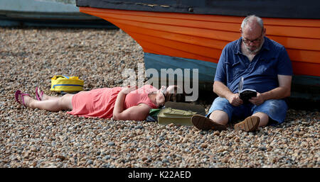 Die Menschen genießen die Bank Urlaub Sonne auf Brighton Beach in Sussex. Stockfoto