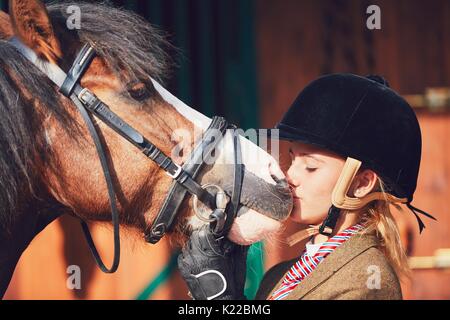 Zwischen Teenager und ihrem Pferd Kiss nach dem Reiten. Stockfoto