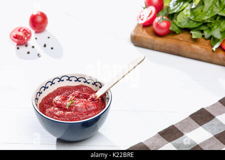 Schüssel mit gehackten Tomaten auf rustikalen Tisch Stockfoto