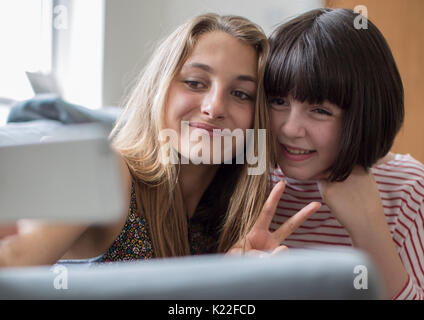Zwei Mädchen im Teenageralter die Selfie im Schlafzimmer zu Hause Stockfoto
