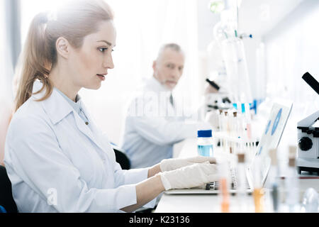 Aufmerksame weibliche Person Arbeiten mit Ihrem Computer Stockfoto