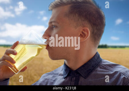 Nahaufnahme eines jungen Mannes aus Glas Bier zu trinken Stockfoto