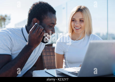 Junge Mädchen drehen auf Musik für afrikanische amerikanische Freund Stockfoto