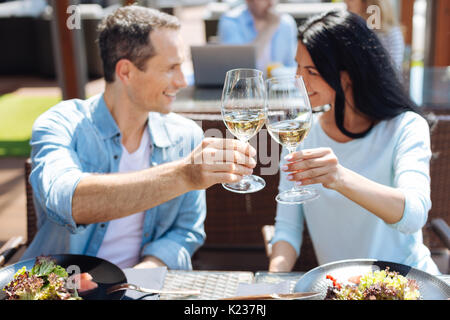 Gläser mit Wein in der Hand ein schönes glückliches Paar Stockfoto