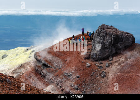 Große Gruppe von Touristen und Reisende ruht im Gipfelkrater des aktiven Avacha Vulkan nach dem Aufstieg auf den Gipfel des Vulkan auf Kamtschatka. Stockfoto
