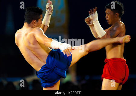 Bangkok, Thailand - 10 April, 2007: Muay Thai Kickboxen mit eingewickelt Hände treten eines zuckte Gegners während traditionelle Ausstellung kickboxing Match ein Stockfoto