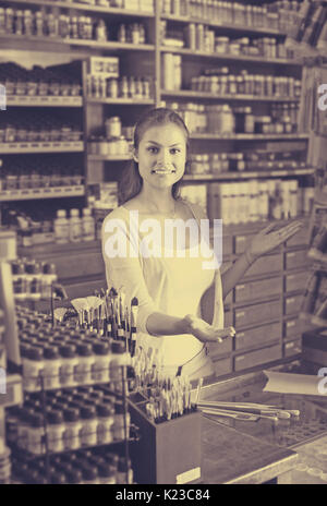 Porträt der jungen fröhliche weibliche Kassierer an der Kasse in der Kunst Shop Stockfoto