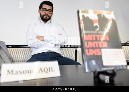 Kurdischen Journalisten Masoud Aqil präsentiert sein Buch 'Mitten unter uns. Wie ich der Folter des ist und entkam er 23.38.39 in Deutschland einholte." (Lit. "Mitten unter uns. Wie entging ich die Folter von ISIS und wurde von ihnen in Deutschland' gefangen) in Berlin, Deutschland, 28. August 2017. Der 24-jährige Mann aus Syrien verbrachte neun Monate als Gefangener der terroristische Milizen islamischen Staat (ISIS). Die ISIS-Kämpfer gefoltert und humiliatied ihn. Er hatte Schmerzen zu leiden und sehen unglaubliche Grausamkeit, bevor er in einem gefangenenaustausch im September 2015 veröffentlicht wurde. Foto: Maurizio Gambarini/dpa Stockfoto