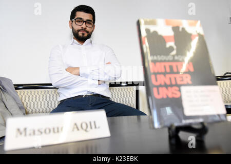 Kurdischen Journalisten Masoud Aqil präsentiert sein Buch 'Mitten unter uns. Wie ich der Folter des ist und entkam er 23.38.39 in Deutschland einholte." (Lit. "Mitten unter uns. Wie entging ich die Folter von ISIS und wurde von ihnen in Deutschland' gefangen) in Berlin, Deutschland, 28. August 2017. Der 24-jährige Mann aus Syrien verbrachte neun Monate als Gefangener der terroristische Milizen islamischen Staat (ISIS). Die ISIS-Kämpfer gefoltert und humiliatied ihn. Er hatte Schmerzen zu leiden und sehen unglaubliche Grausamkeit, bevor er in einem gefangenenaustausch im September 2015 veröffentlicht wurde. Foto: Maurizio Gambarini/dpa Stockfoto