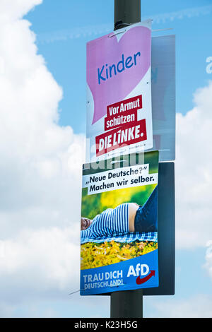 Berlin, Deutschland. 28. August 2017. Partei politische Plakate für eine linke Partei, die Linke (Die Linke) (oben) mit der Meldung, 'Kinder - Schutz vor Armut" im Gegensatz zu den Rechtsextremen Alternative für Deutschland Partei, AfD, mit Meldung "Neue Deutsche? Let's Do it Uns'' im östlichen Bezirk von Berlin für die Bundestagswahl am 24. September 2017. Credit: Iain Masterton/Alamy leben Nachrichten Stockfoto