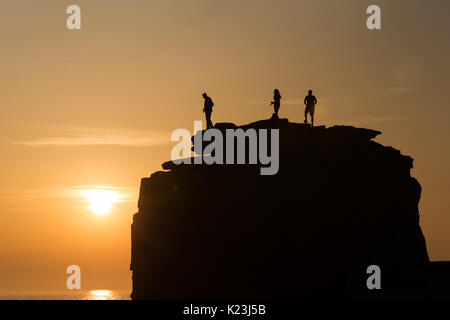 Portland Bill, Dorset, Großbritannien. 28 Aug, 2017. UK Wetter. Als einer der wärmsten Feiertage im neuen Gedächtnis zu einem Ende kommt, Touristen bewundern Sie den Sonnenuntergang vom Preikestolen auf Portland Bill, Dorset. Credit: Peter Lopeman/Alamy leben Nachrichten Stockfoto