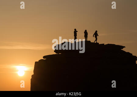 Portland Bill, Dorset, Großbritannien. 28 Aug, 2017. UK Wetter. Als einer der wärmsten Feiertage im neuen Gedächtnis zu einem Ende kommt, Touristen bewundern Sie den Sonnenuntergang vom Preikestolen auf Portland Bill, Dorset. Credit: Peter Lopeman/Alamy leben Nachrichten Stockfoto