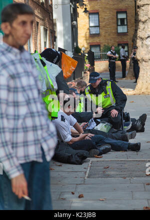 Notting Hill, London, UK, 28. August 2017. Mitglieder der Polizei eine kurze Rast. Notting Hill Carnival ist Europas größte Street Festival feiert Londons Karibische Gemeinschaft und multikulturelle Erbe seit 1964 in Notting Hill, Ladbroke Grove und Westbourne Park. Credit: Imageplotter Nachrichten und Sport/Alamy leben Nachrichten Stockfoto