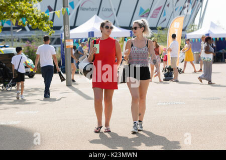 London, Großbritannien. 28. August 2017. Zwei Frauen gehen in den Sonnenschein in der Queen Elizabeth Olympic Park in Stratford. Credit: Vickie Flores/Alamy leben Nachrichten Stockfoto