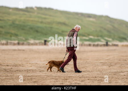 Southport, Merseyside, 30. August 2017. UK Wetter. Ein kühles und über cast Start in den Tag über den Nordwesten von England als Dog Walker ihre geliebten Haustiere für einige Morgengymnastik am strand in Southport, Merseyside. Credit: cernan Elias/Alamy leben Nachrichten Stockfoto