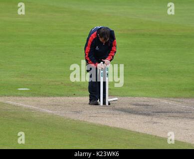 Manchester, Großbritannien. 30 Aug, 2017. Ein Mitglied von Lancashire Bodenpersonal setzt oben die Stümpfe für die Fortsetzung des Spiels, nachdem Spiel war wegen starker Regen während der Match gegen Warwickshire am dritten Tag der County Championship Match im Emirates Old Trafford unterbrochen. Quelle: John Fryer/Alamy leben Nachrichten Stockfoto