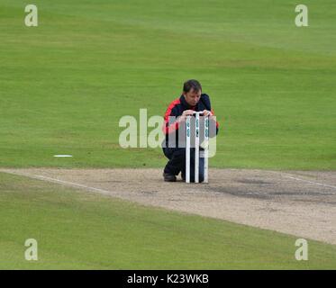 Manchester, Großbritannien. 30 Aug, 2017. Ein Mitglied von Lancashire Bodenpersonal setzt oben die Stümpfe für die Fortsetzung des Spiels, nachdem Spiel war wegen starker Regen während der Match gegen Warwickshire am dritten Tag der County Championship Match im Emirates Old Trafford unterbrochen. Quelle: John Fryer/Alamy leben Nachrichten Stockfoto