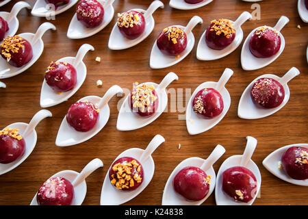 Ansicht von oben Dessert rote Kugeln auf weißen Löffel Stockfoto