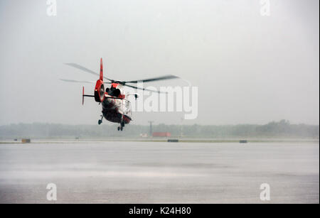 Eine US Coast Guard MH-65 Dolphin Helikopter Köpfe in strömenden Regen auf eine Rettungsaktion gestrandete Einwohner zu unterstützen, nachdem massive Überflutungen überwältigt von Straßen und Gebäuden in der ganzen Stadt in die Folgen des Hurrikans Harvey 27. August 2016 in Houston, Texas. Stockfoto