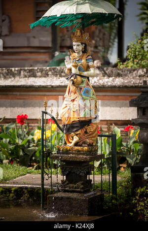 Statue mit Regenschirm im Pura Ulun Danau Bratan Tempel Indonesien Bali. Stockfoto