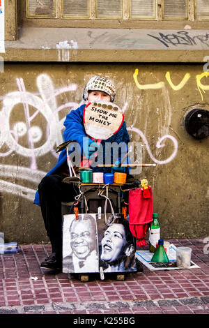 Ältere Frau mit einem Plakat auf der Straße in San Telmo Nachbarschaft. Buenos Aires, Argentinien. Stockfoto