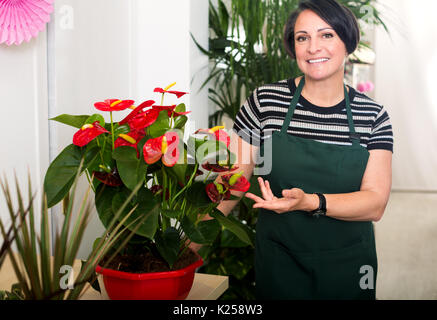 Porträt Frau Florist das Tragen einer Schürze und glücklich im Blumengeschäft und lächelnd Stockfoto