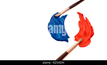 Zwei Farbpinsel mit Abstrichen von oranger und blauer Farbe Einander gegenüber isoliert auf weißem Hintergrund Stockfoto