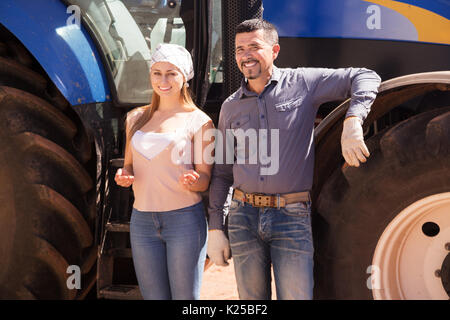 Positiver Mann und Frau Bauern neben großen Feld Motor und Reden Stockfoto