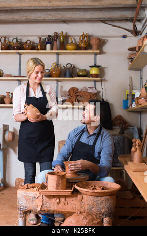 Freundliche Handwerker, Topf mit Keramik Rad und im Gespräch mit Frau Kollegin in der Keramik studio Stockfoto