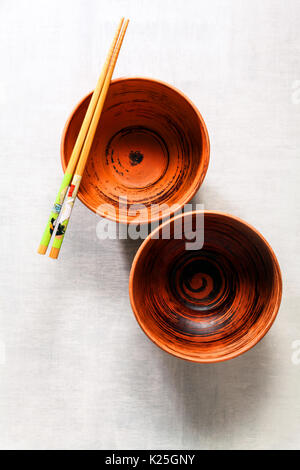 Leere Schalen und Essstäbchen auf weißen Stein Hintergrund Stockfoto