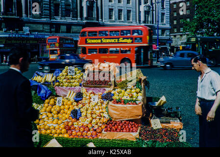 Obstverkäufer vor Marble Arch's Odeon Cinema. Bild aus dem Jahr 1959, Ein Moment in der Zeit, aufgenommen mit einem Obst- und Gemüsestand zusammen mit dem Händler. Stockfoto