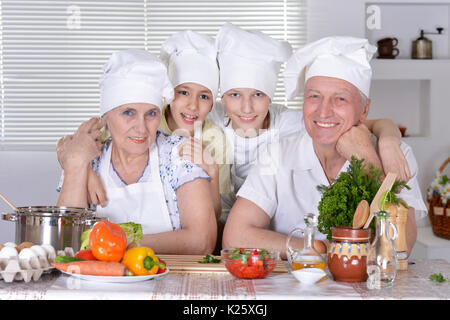 Großeltern mit Enkeln zusammen kochen in der Küche Stockfoto