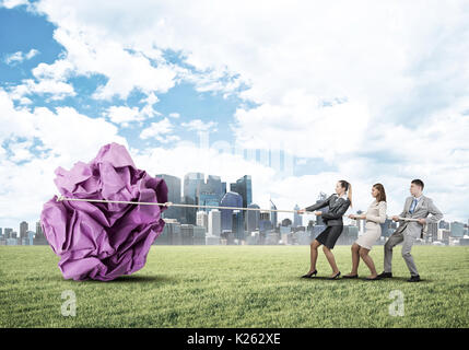 Junge Geschäftsleute im Freien und riesige Papier Kugel als Symbol der Kreativität Stockfoto