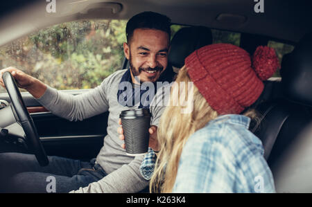 Junges Paar mit dem Auto reisen und sich an der Suche. Romantische junge Paar auf einem Road Trip. Stockfoto