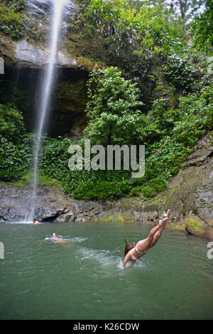 Besucher schwimmen im La Sierpe Watefall, Nationaler Naturpark Uramba, Bahia Malaga, Kolumbianische Pazifikküste Stockfoto