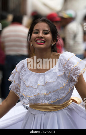 Juni 17, 2017 Pujili, Ecuador: indigene Tänzerinnen aus dem Amazonasgebiet an der Corpus Christi jährliche Parade im kolonialen Stil Kleid am Corpu Stockfoto