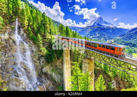 Zermatt, Schweiz. Gornergrat touristischen Zug mit Wasserfall, Brücke und Matterhorn. Wallis. Stockfoto