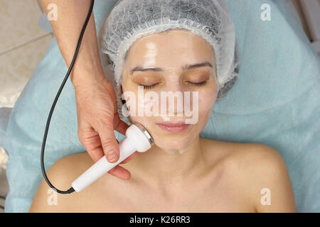 Junge Frau, die sich einer phonophorese. Mädchen in der Schönheitsklinik. Verbesserung der adsorptiven Eigenschaften der Haut. Stockfoto