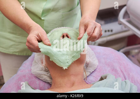 Kosmetikerin entfernen Gesichtsmaske. Frau in der kosmetologie Klinik. Stockfoto