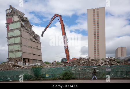 High rise apartment Block durch die Maschine neben neuen Gebäude aus Trümmern in der Stadt Glasgow, Schottland abgerissen Stockfoto