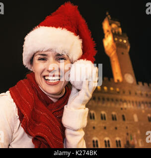 Reise voller Inspiration zur Weihnachtszeit in Florenz. Portrait von glücklich moderne touristische Frau in Weihnachten hat an der Vorderseite des Palazzo Vecchio in Flo Stockfoto