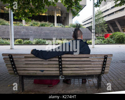 Ein Mann mit einem mohican Haarschnitt entspannen auf einer Werkbank Stockfoto