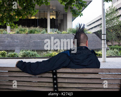 Ein Mann mit einem mohican Haarschnitt entspannen auf einer Werkbank Stockfoto