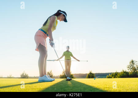 Passende Frau Ausübung schlagen Technik während der Golf Klasse mit einem Stockfoto