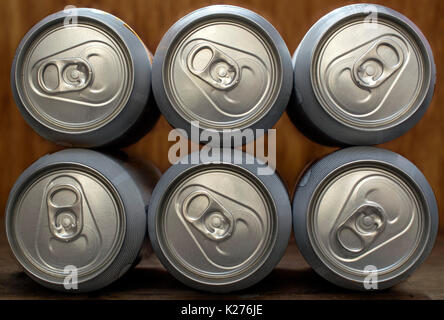 Sechs frontal organisiert Bier oder Limo silber Aluminiumdosen, auf einer hölzernen Hintergrund Stockfoto