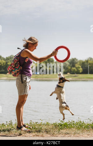 Frau spielen mit Hund auf die Natur Stockfoto