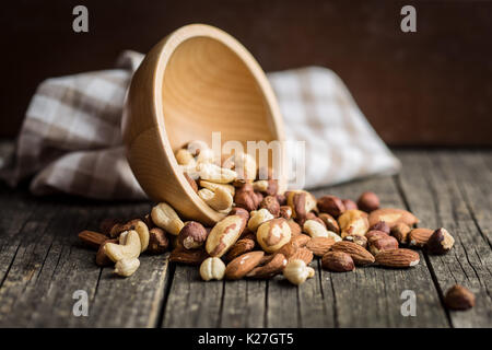 Verschiedene Arten von Nüssen. Haselnüsse, Walnüsse, Mandeln, Paranüsse, Pistazien auf alten Holztisch. Stockfoto