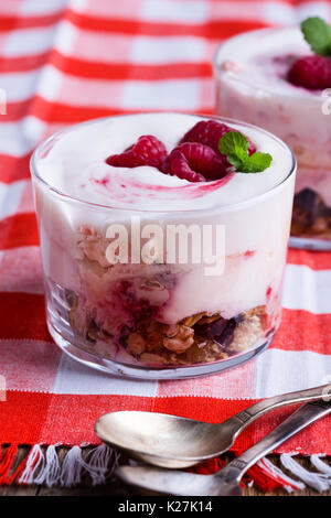 Himbeer trifle mit knackig gerösteten Haferflocken und getrocknete Früchte, Eton mess Stil Müsli Nachtisch auf altmodische rot Serviette serviert. Stockfoto